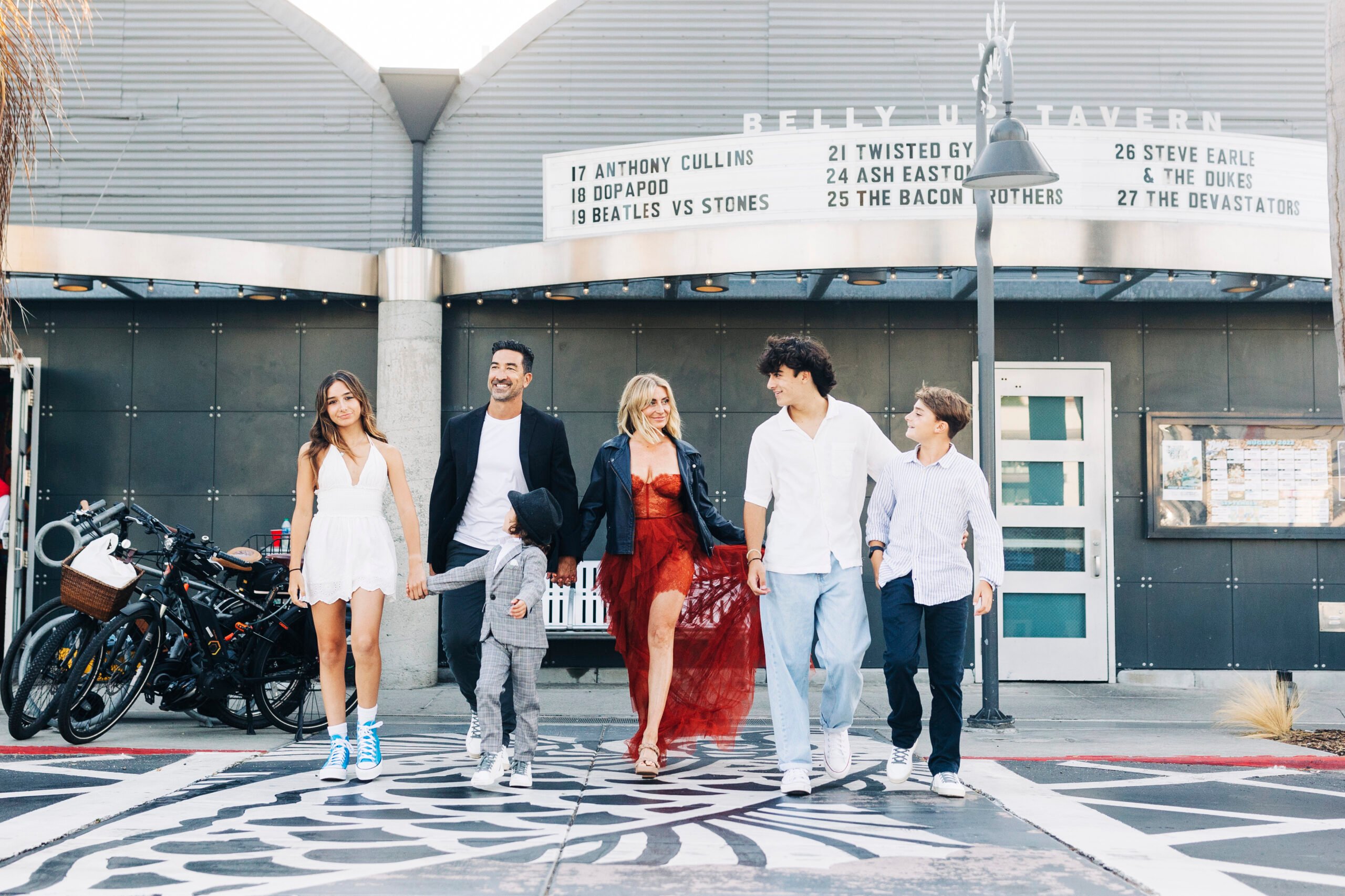 A family of six walks together outside, away from a movie theater.