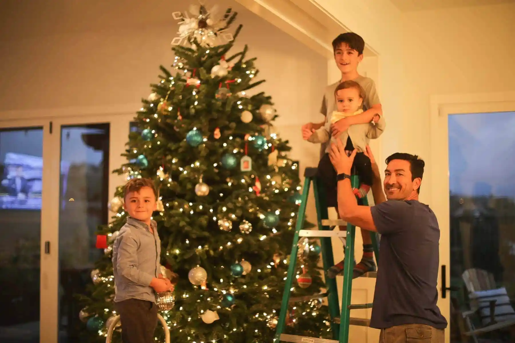 dad helping kids decorate the christmas tree