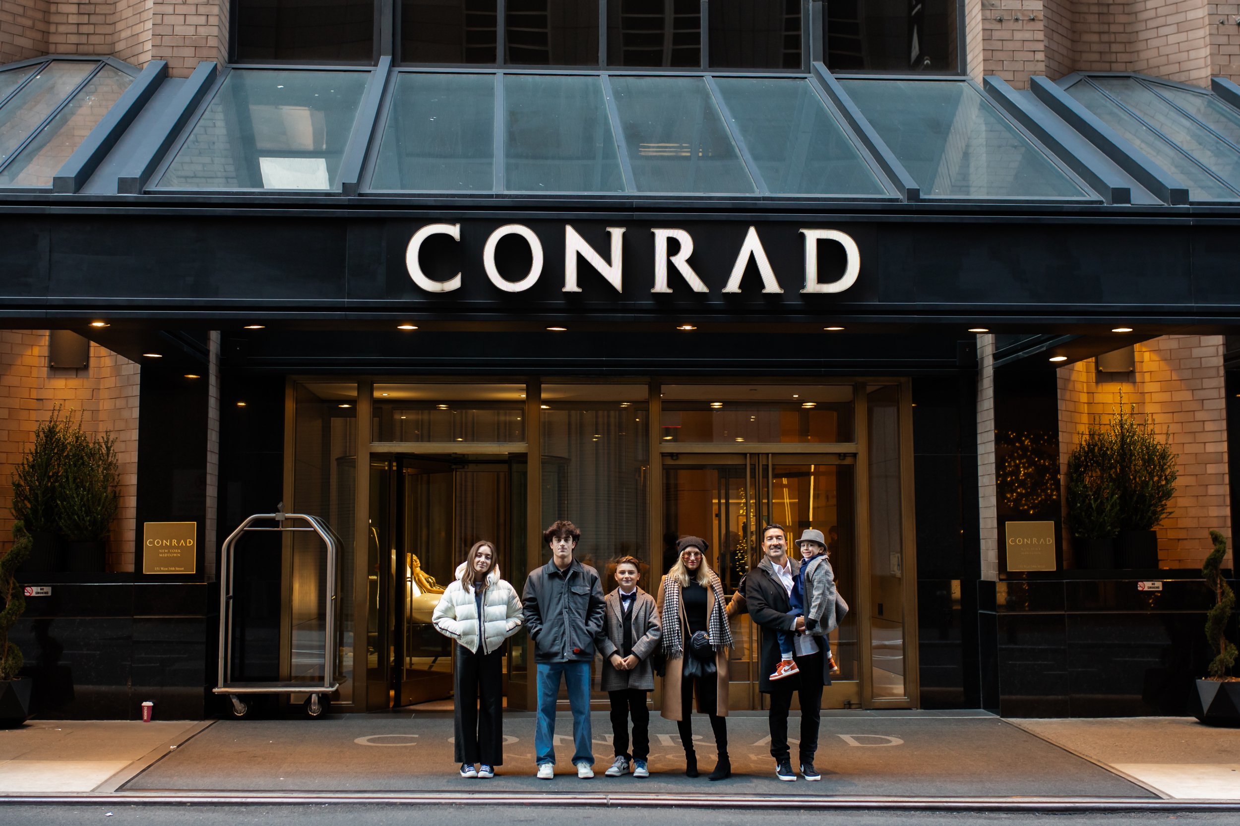 family in front of conrad hotel