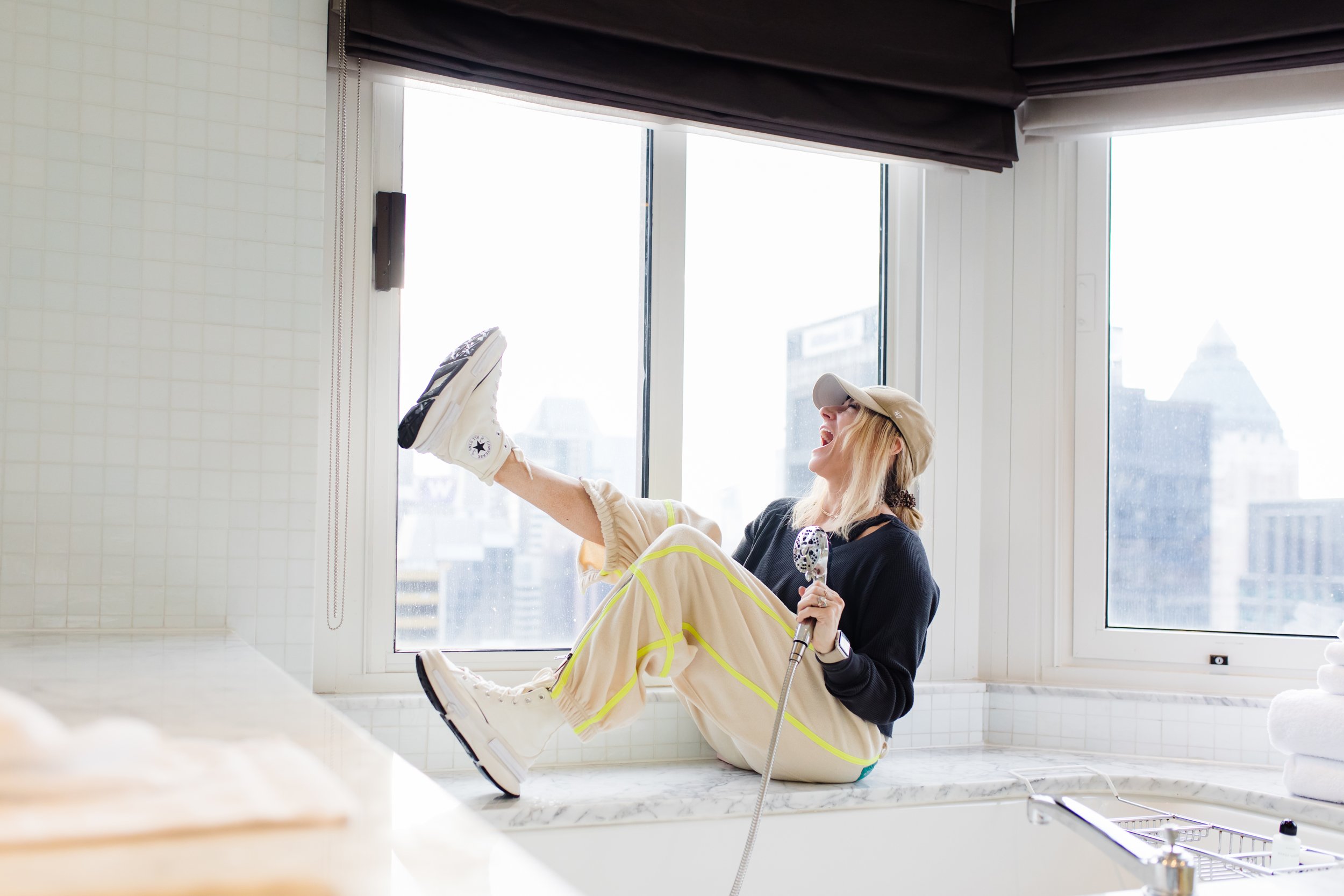 woman laughing beside bathtub