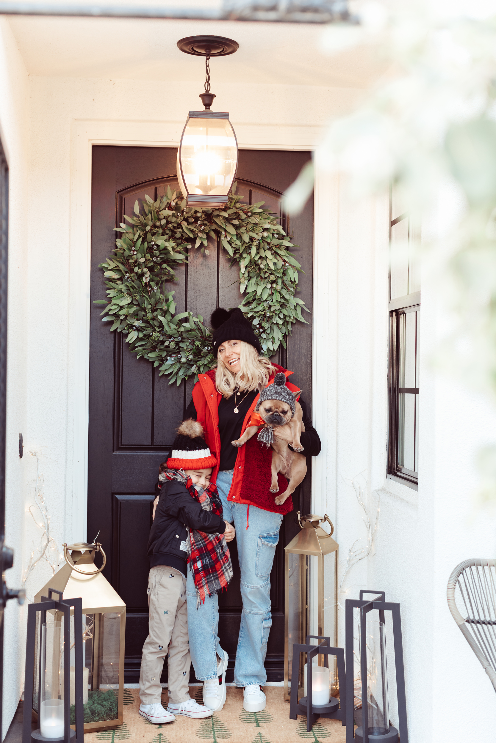 mom and son with their dog outside front door