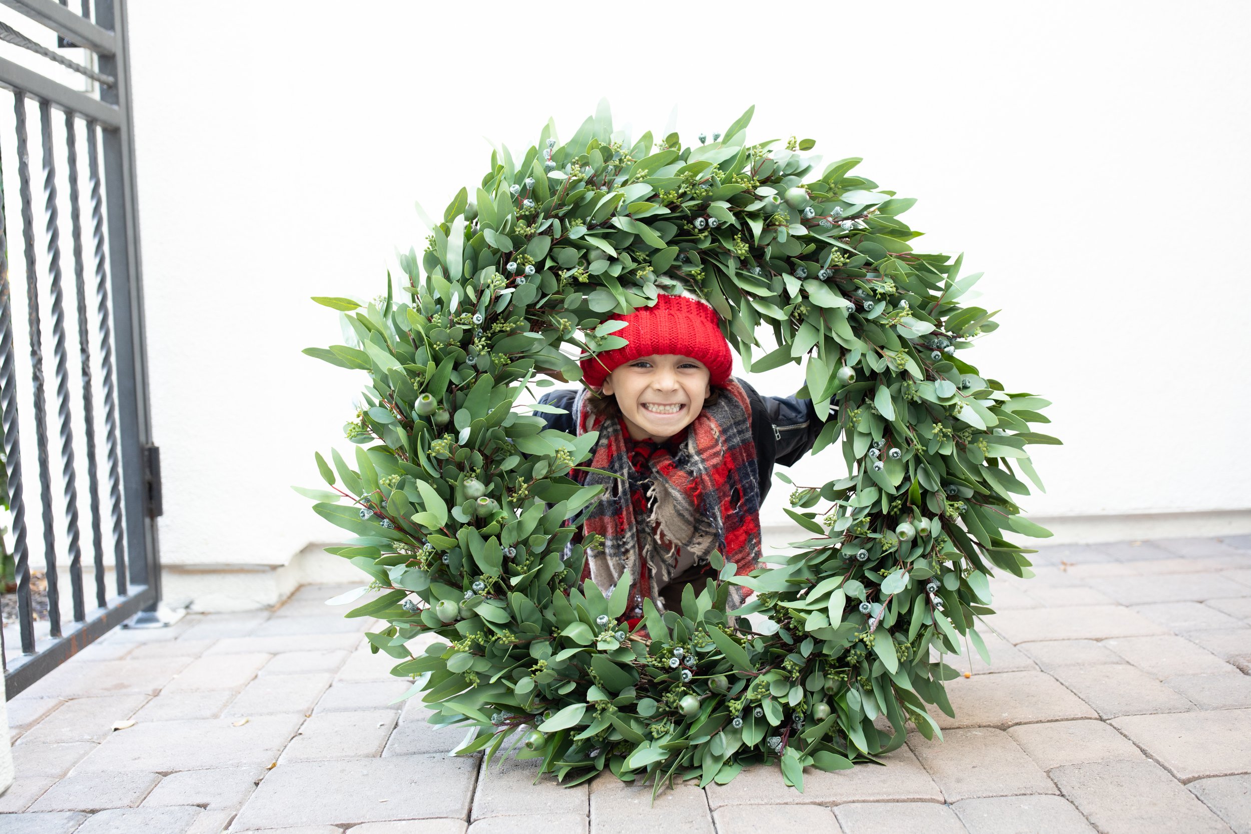 boy smiling through a wreath