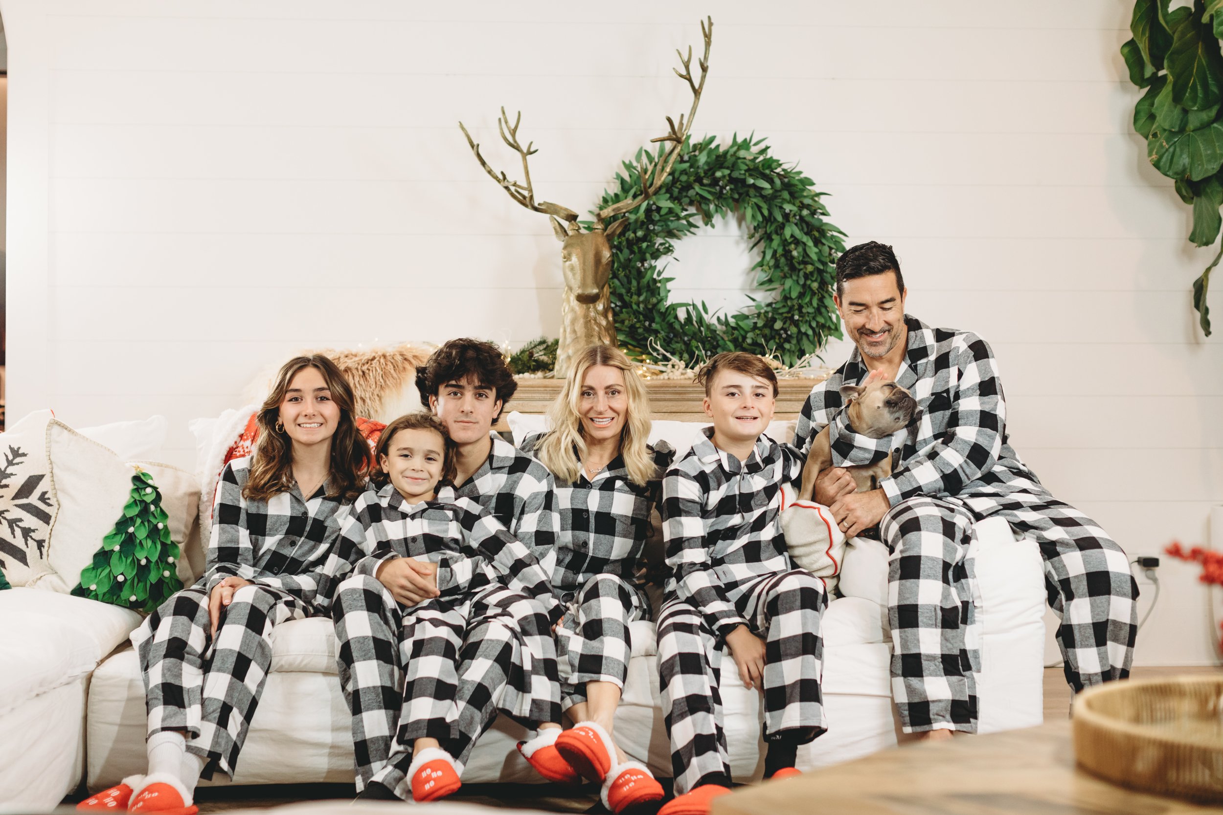 family sitting on couch in matching pjs