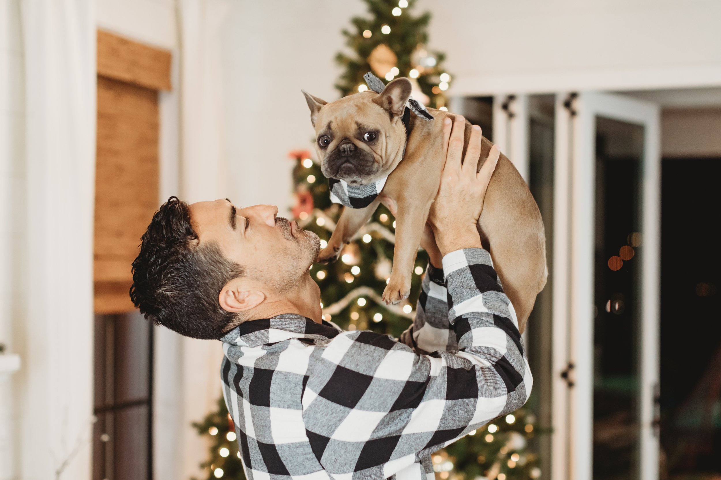 man holding up his dog