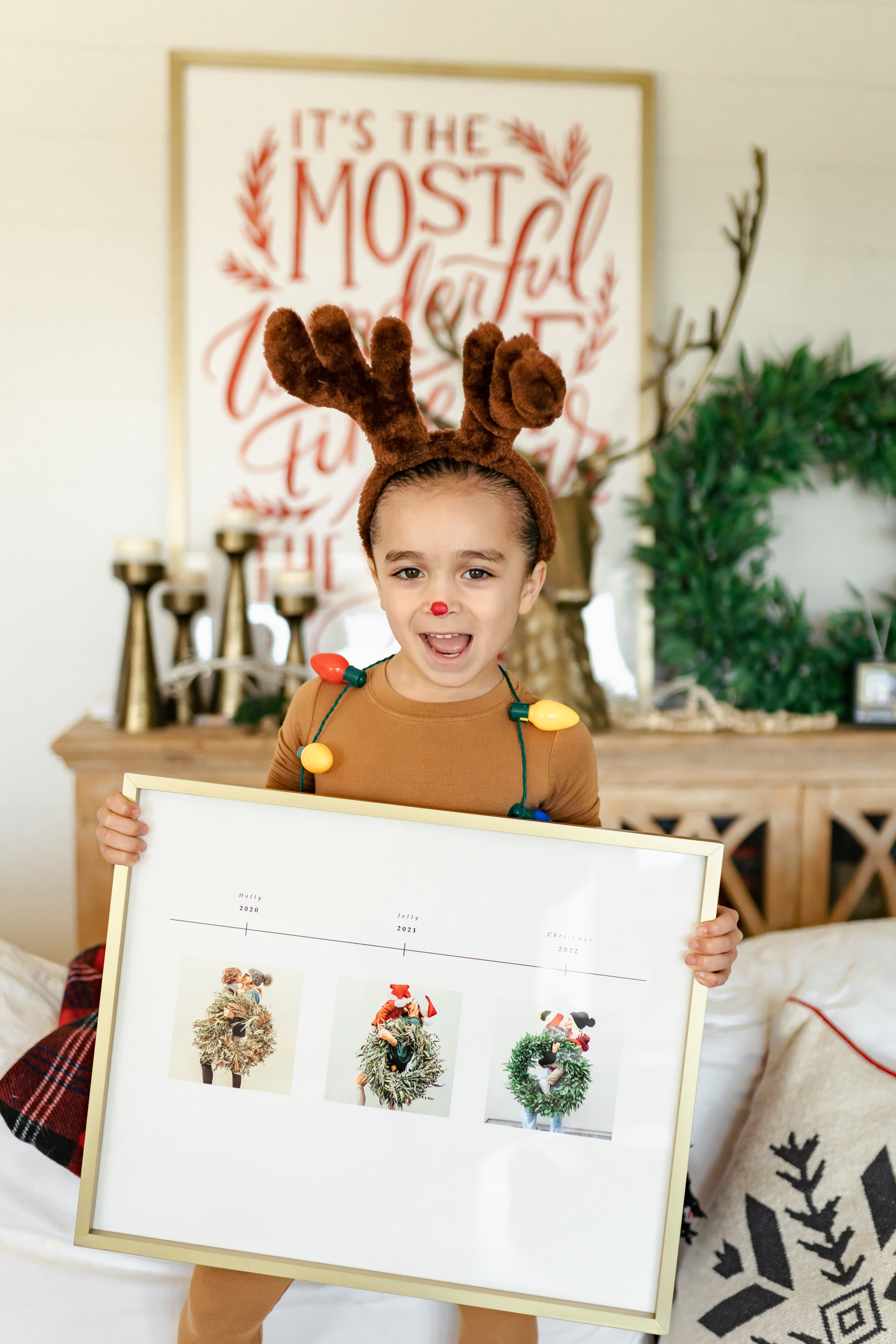 boy dressed as reindeer holding photo