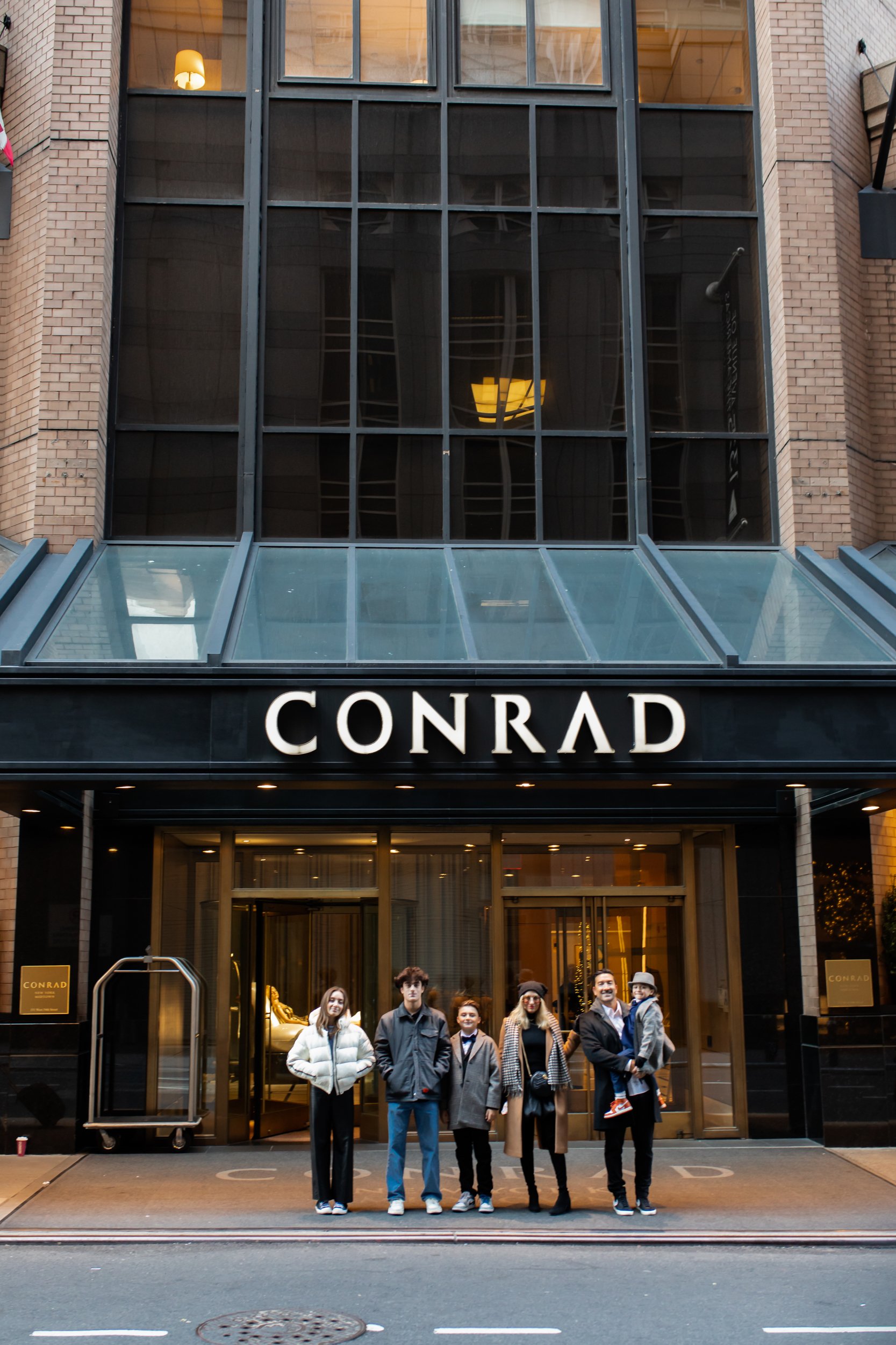 family in front of the conrad in new york