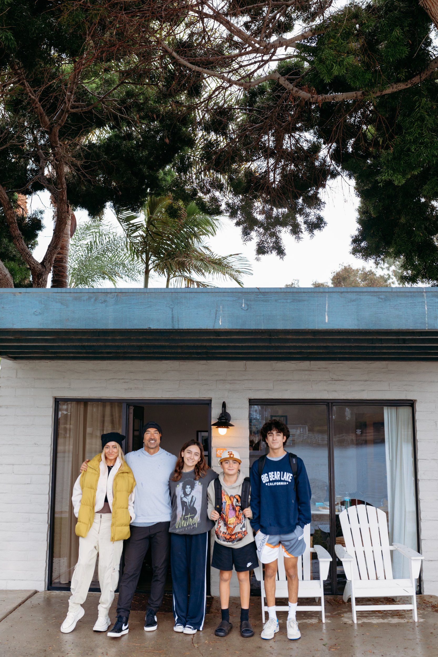 A family stands outside their house together.