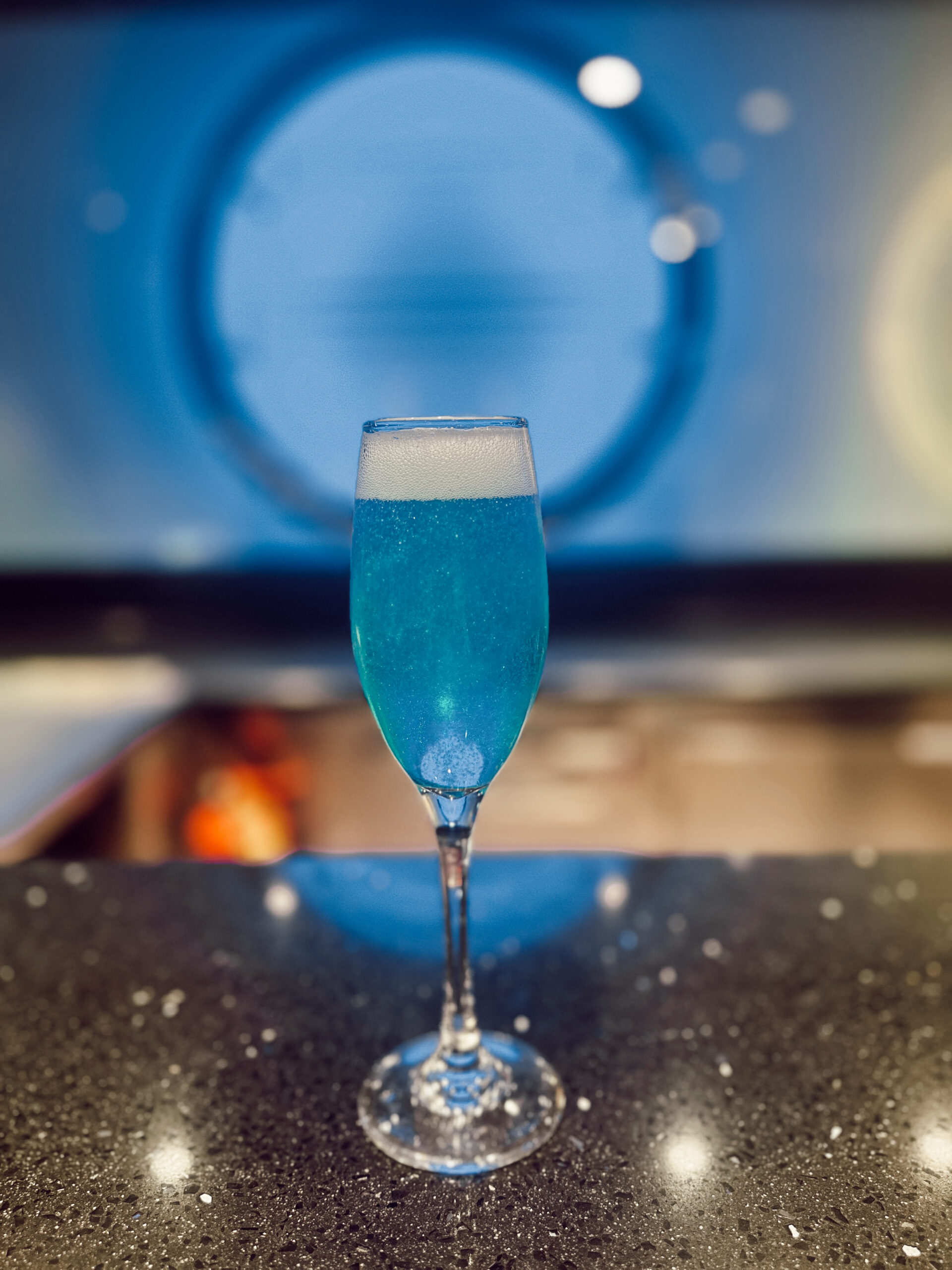 A blue cocktail sitting on a table.