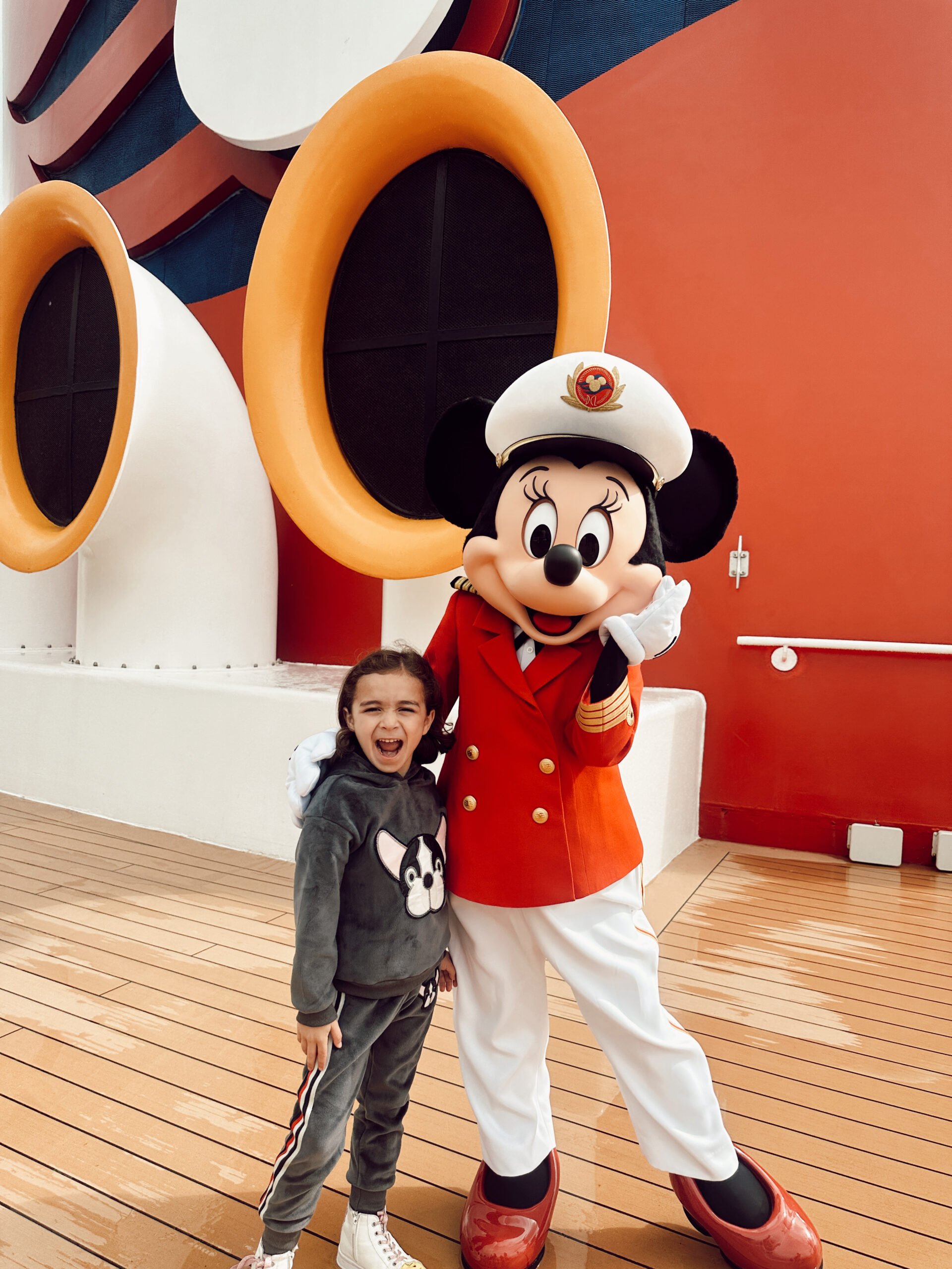 A boy and Minnie Mouse on the deck of a Disney cruise ship.