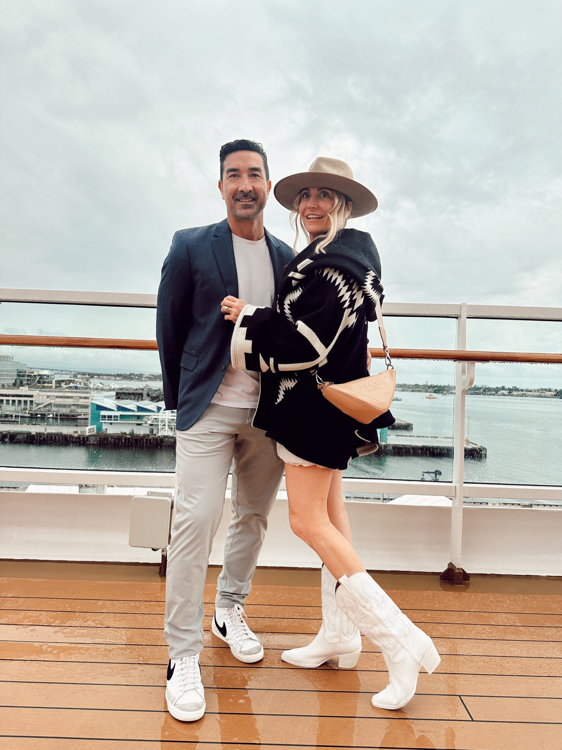 A couple hugging as they stand on the deck of a ship.