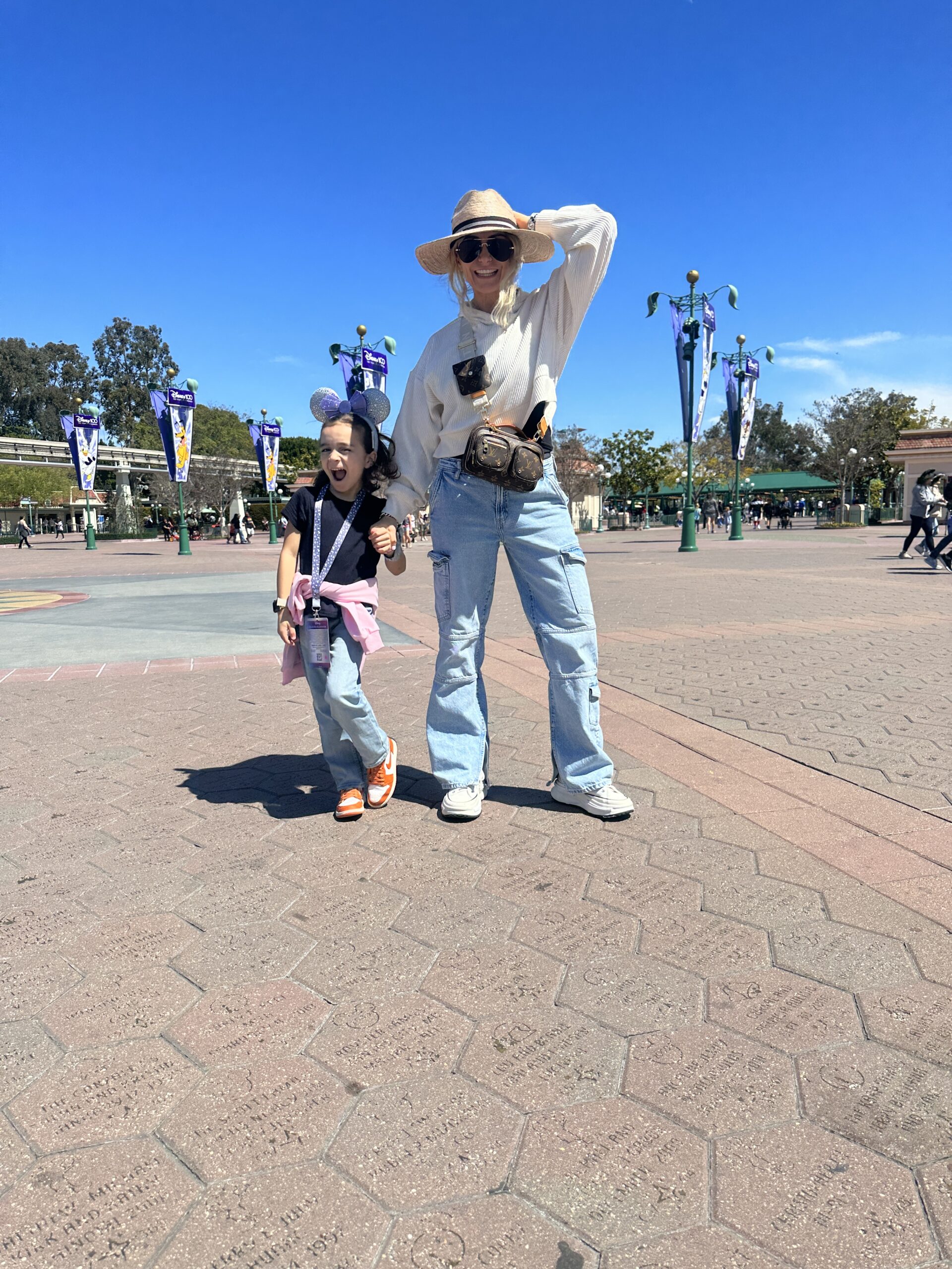 A mom walking around with her toddler at Disneyland. 
