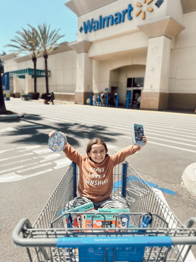 boy holding toys in cart at walmart