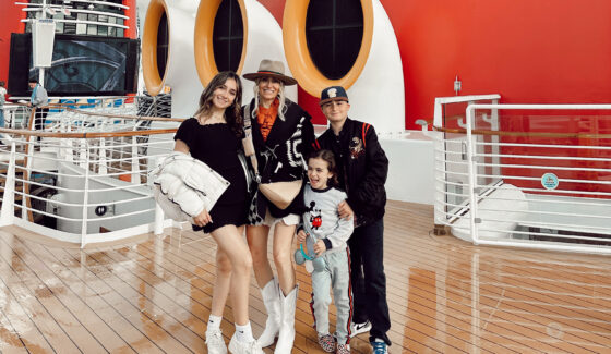 A mom and her kids posing on the deck of a Disney Cruise ship.