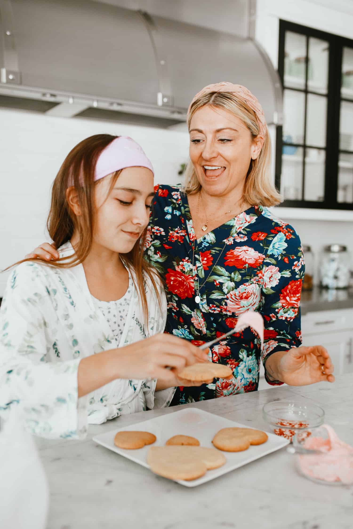 Attractive mother and daughter in the kitchen baking cookies.