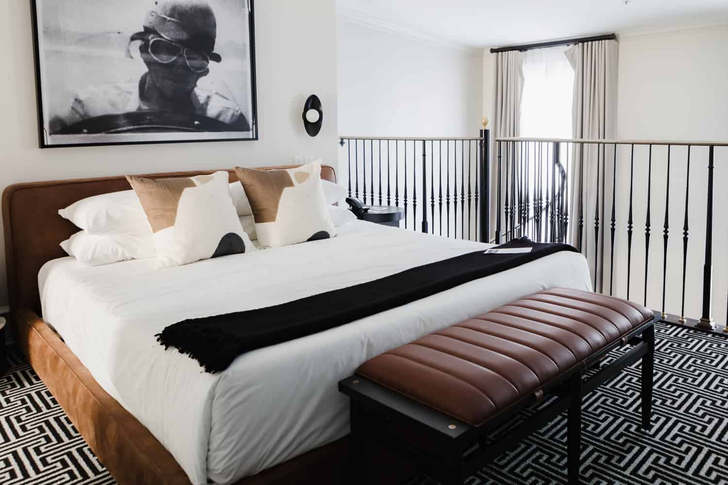A luxurious bedroom with white, black and gold bedding. 