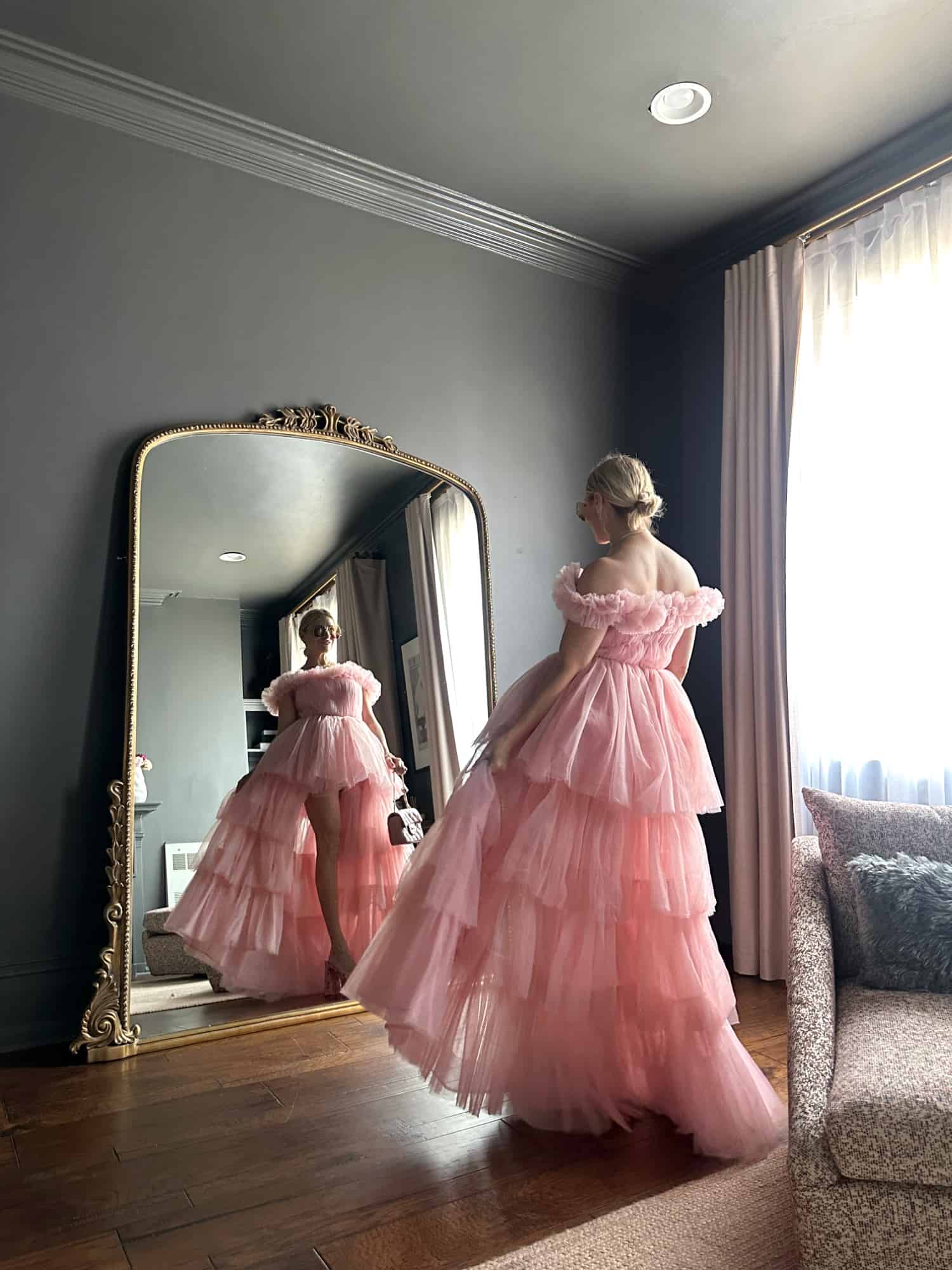 woman standing in pink tulle dress in front of a mirror