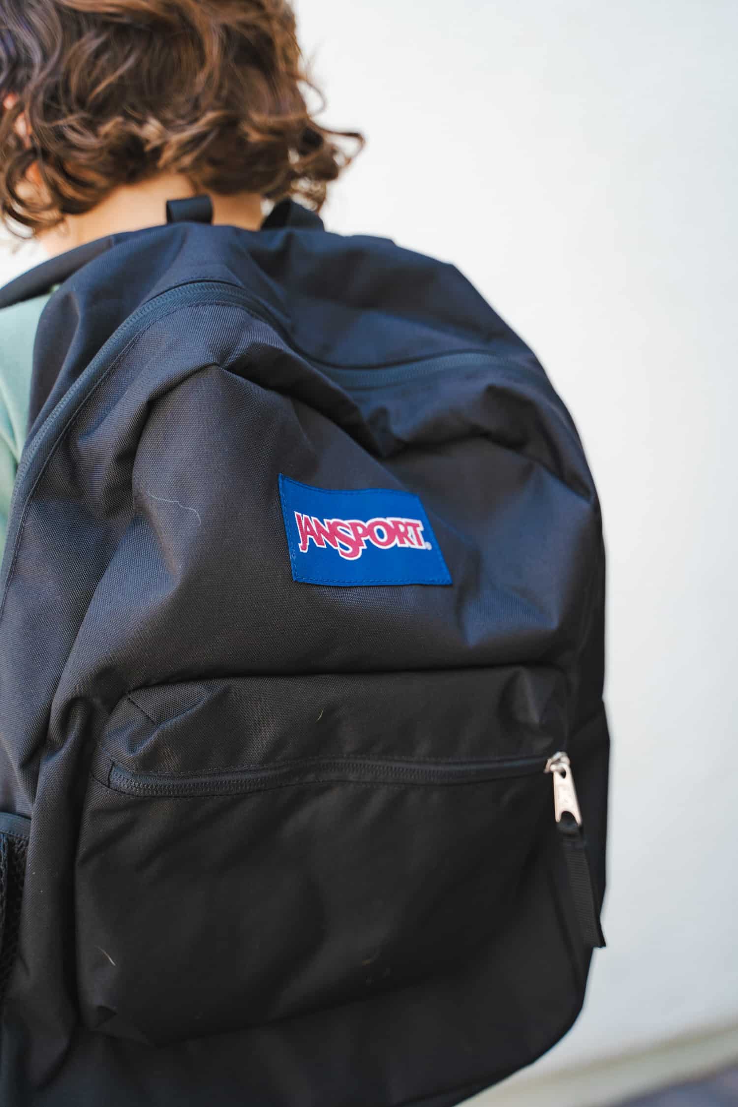 An up close view of a JanSport backpack on a child's back.