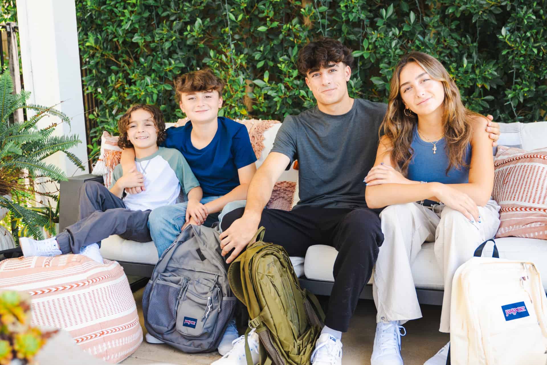 A family of 4 siblings. From left to right are a young boy, tween boy, teen boy and teen girl all wearing new back-to-school clothing trends from Kohl's.