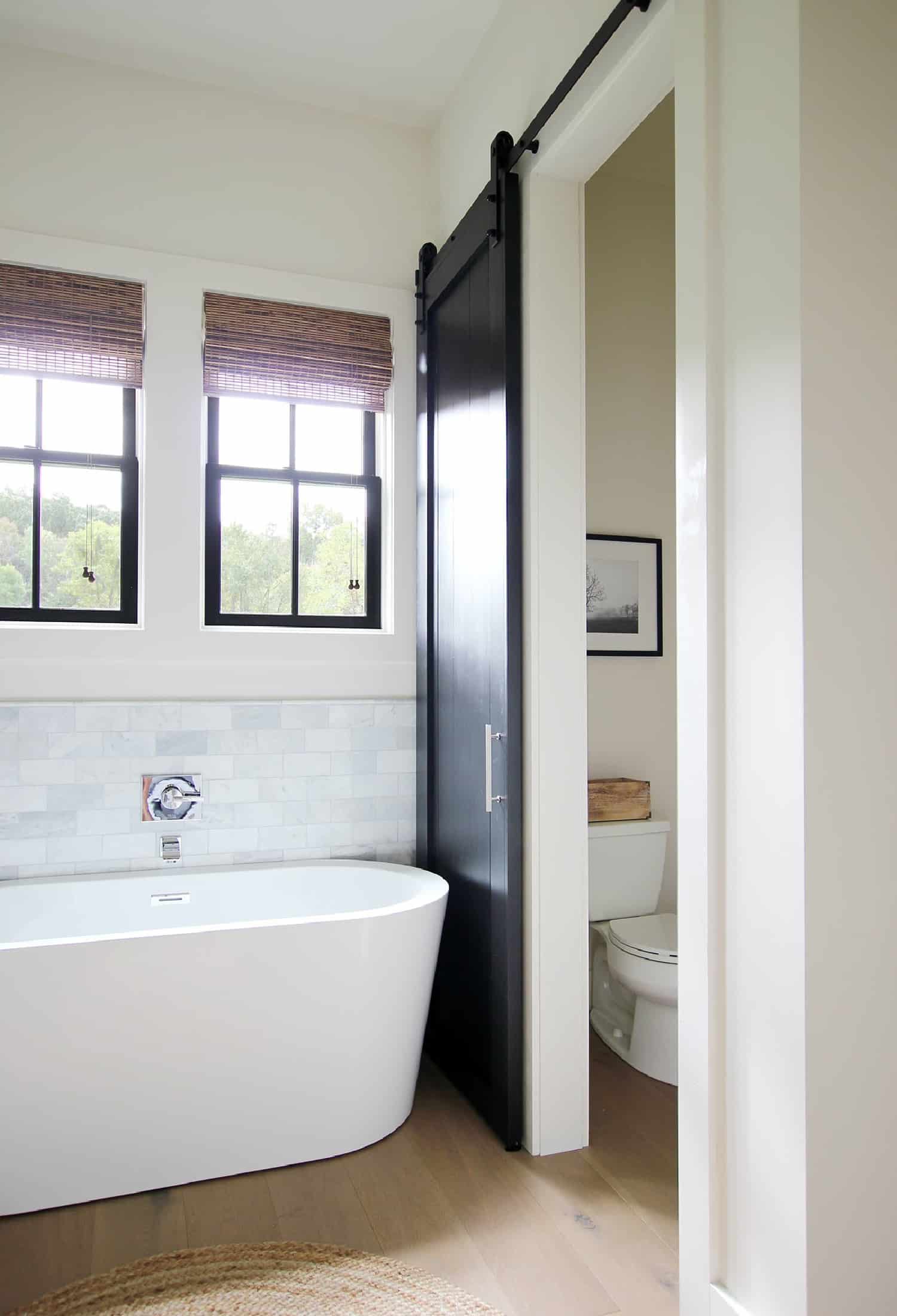 A modern farmhouse bathroom with a sliding barn door.