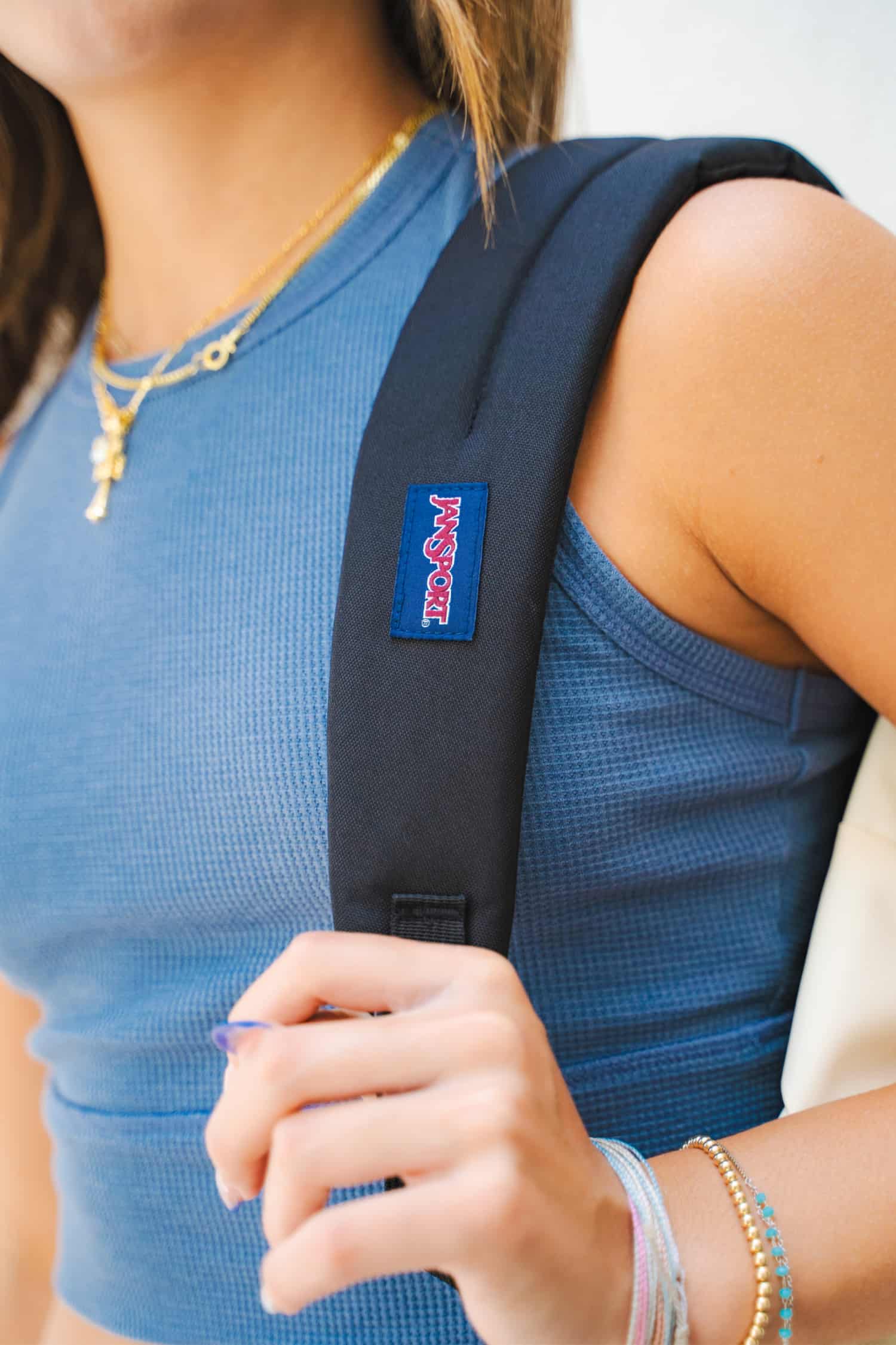 Up close view of JanSport backpack strap over a girl's shoulder.