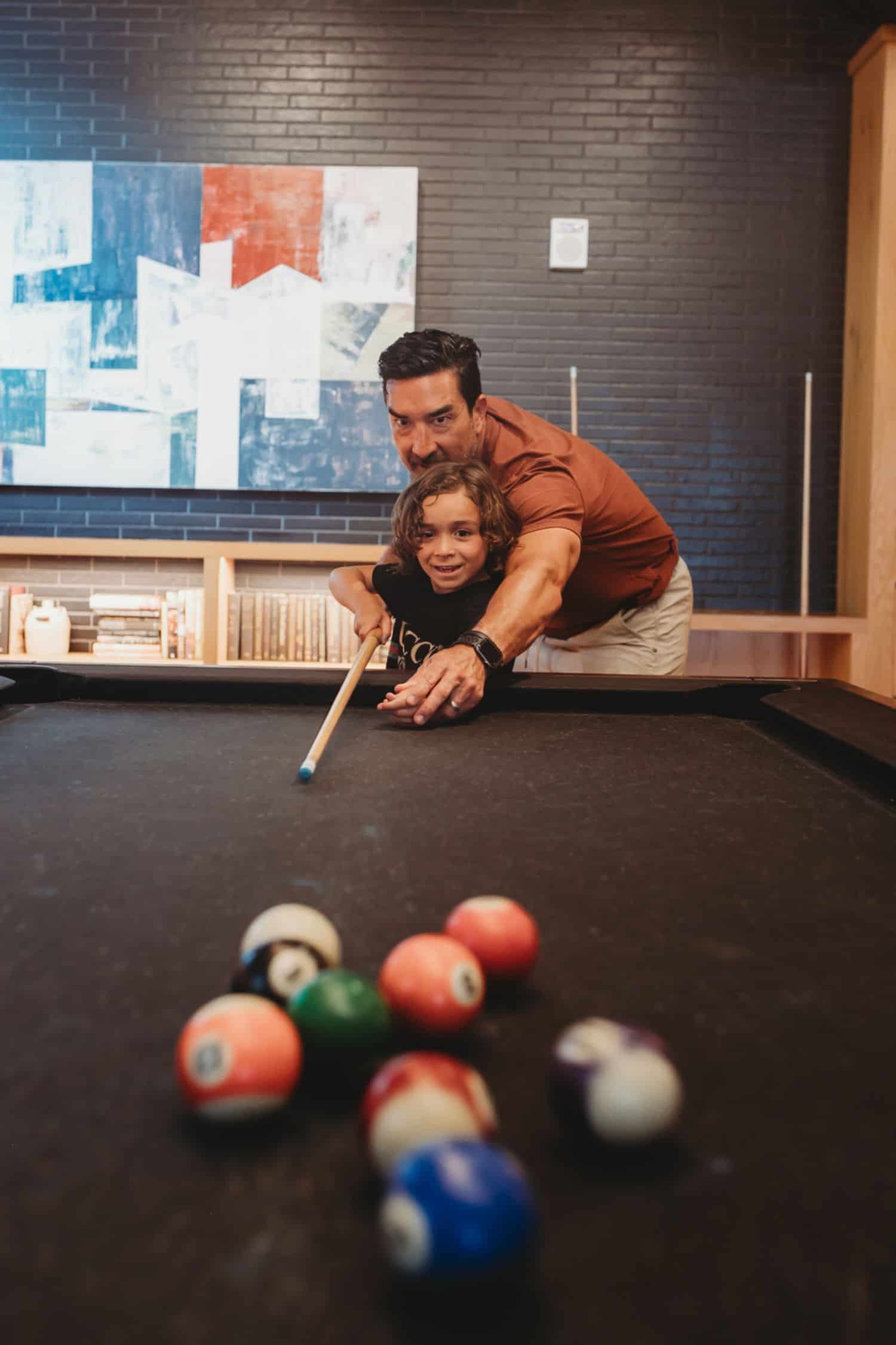 father and son playing pool