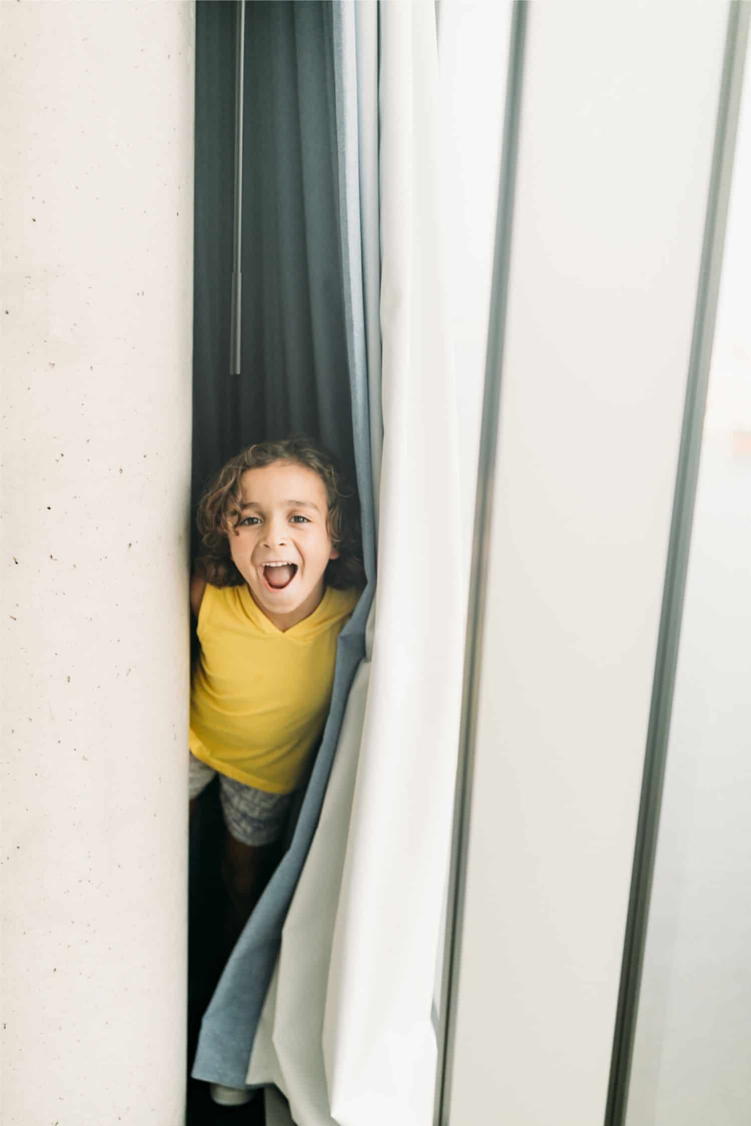 boy looking through blinds