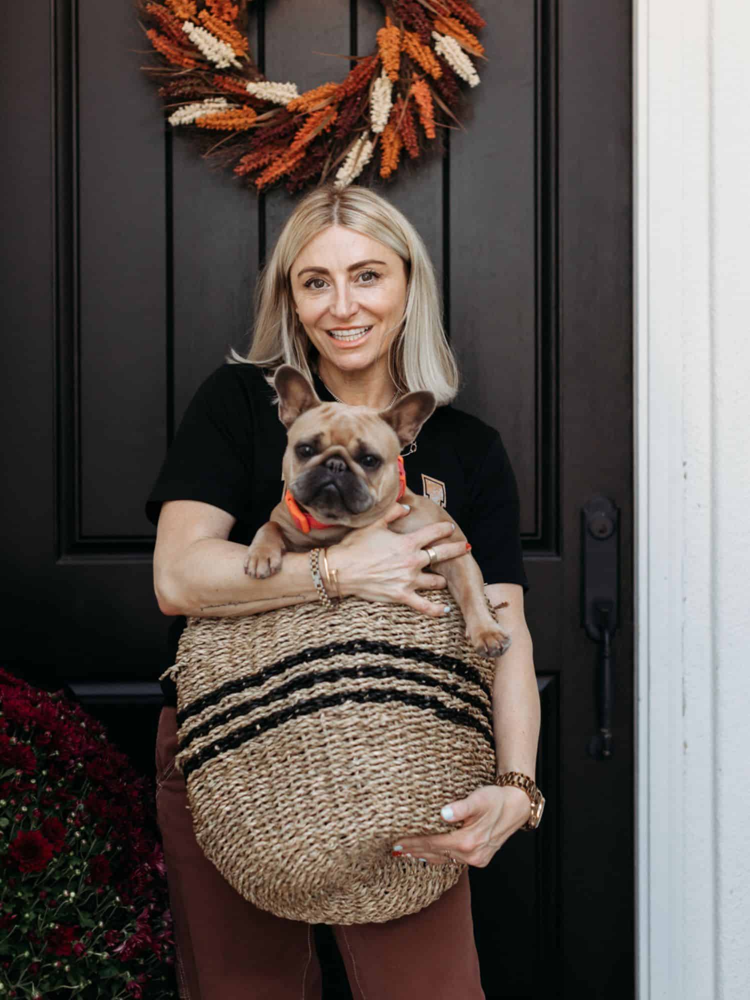 woman holding a basket with a dog in it