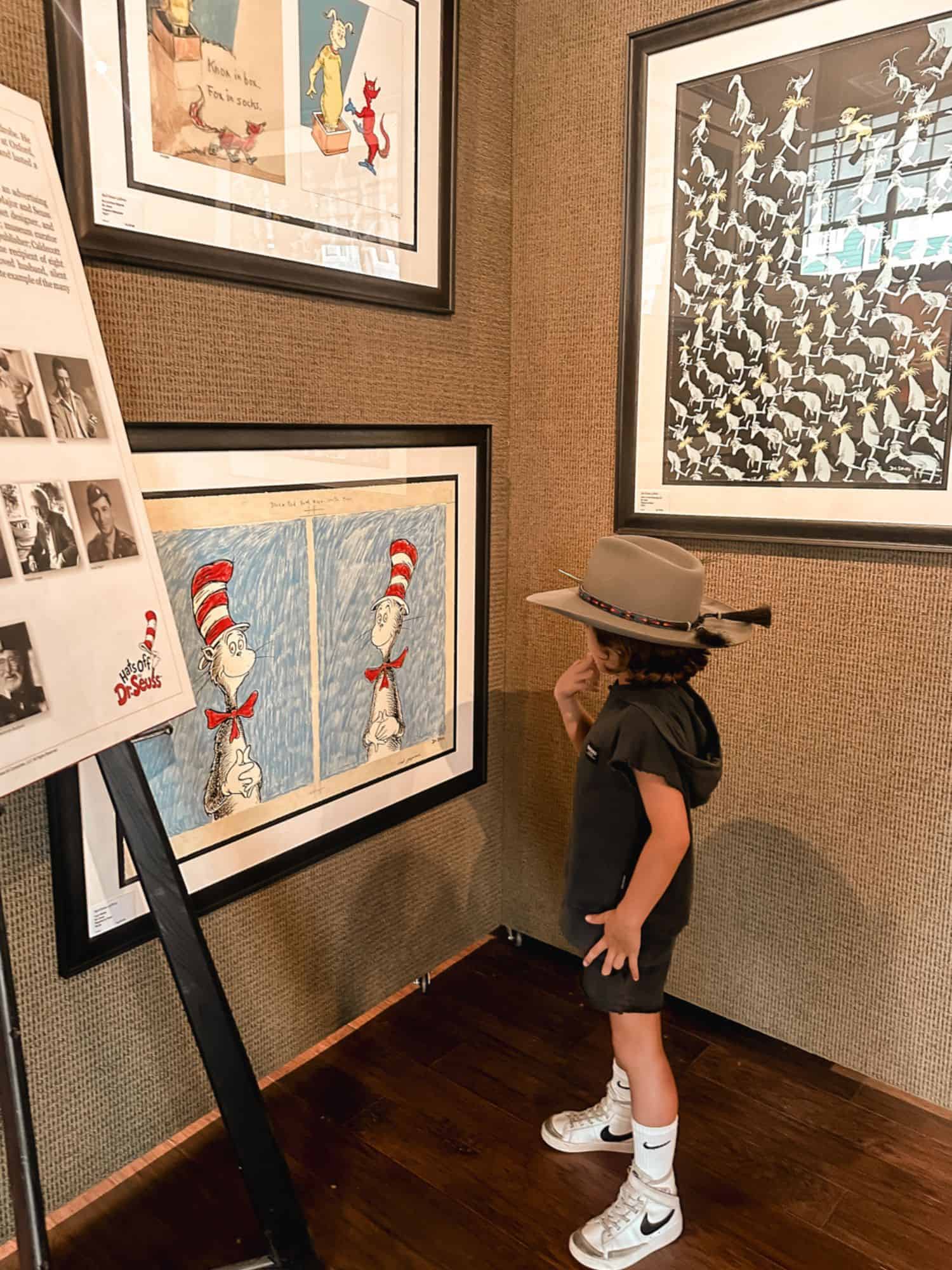 boy standing in front of artwork