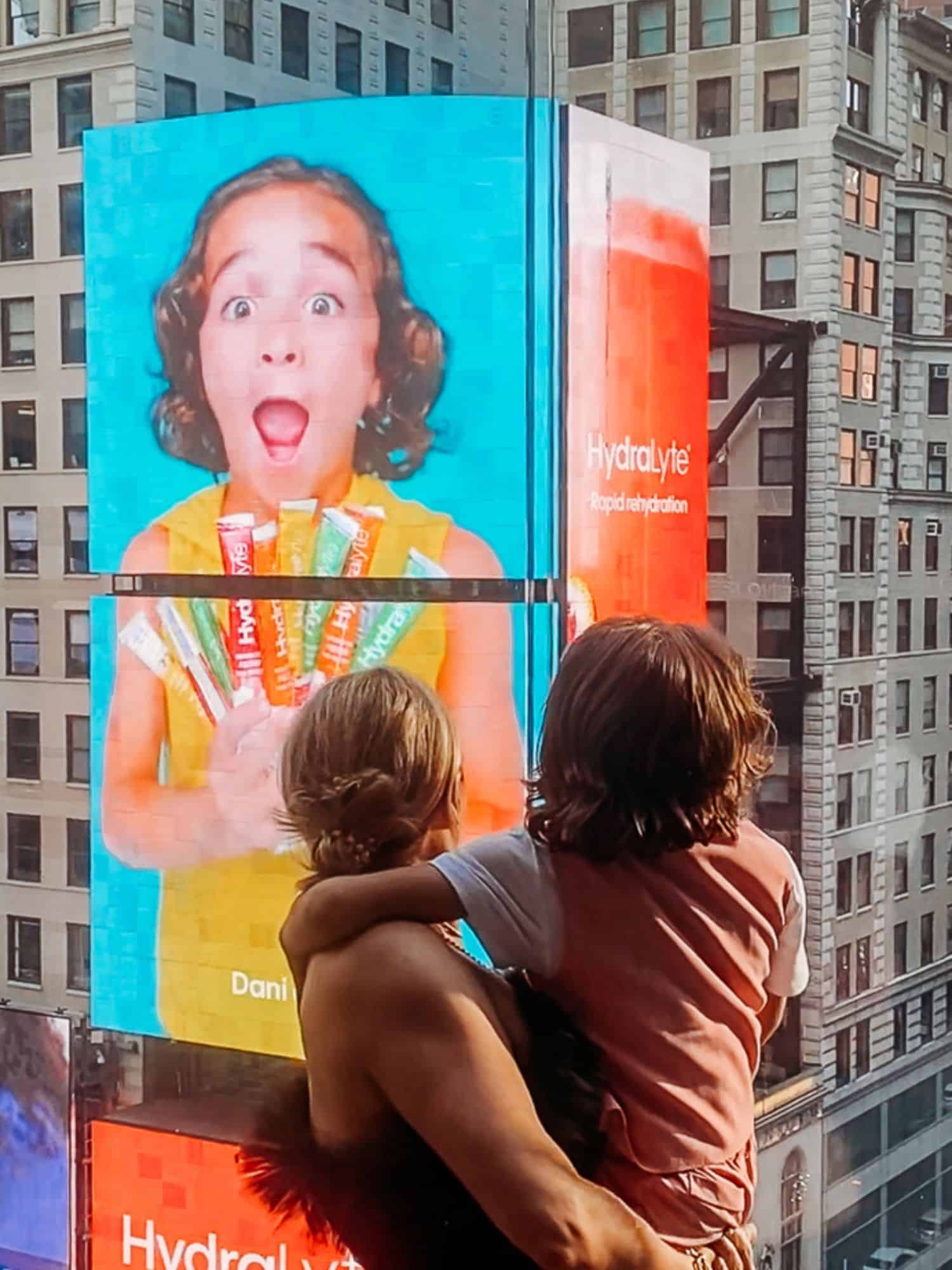 lady and boy looking at a billboard with a boy