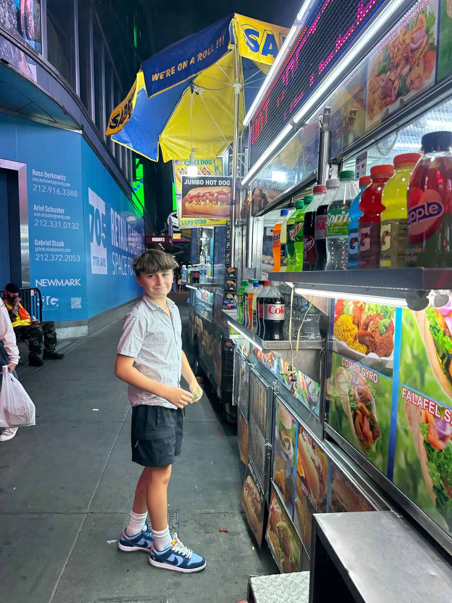 boy standing next to a food truck