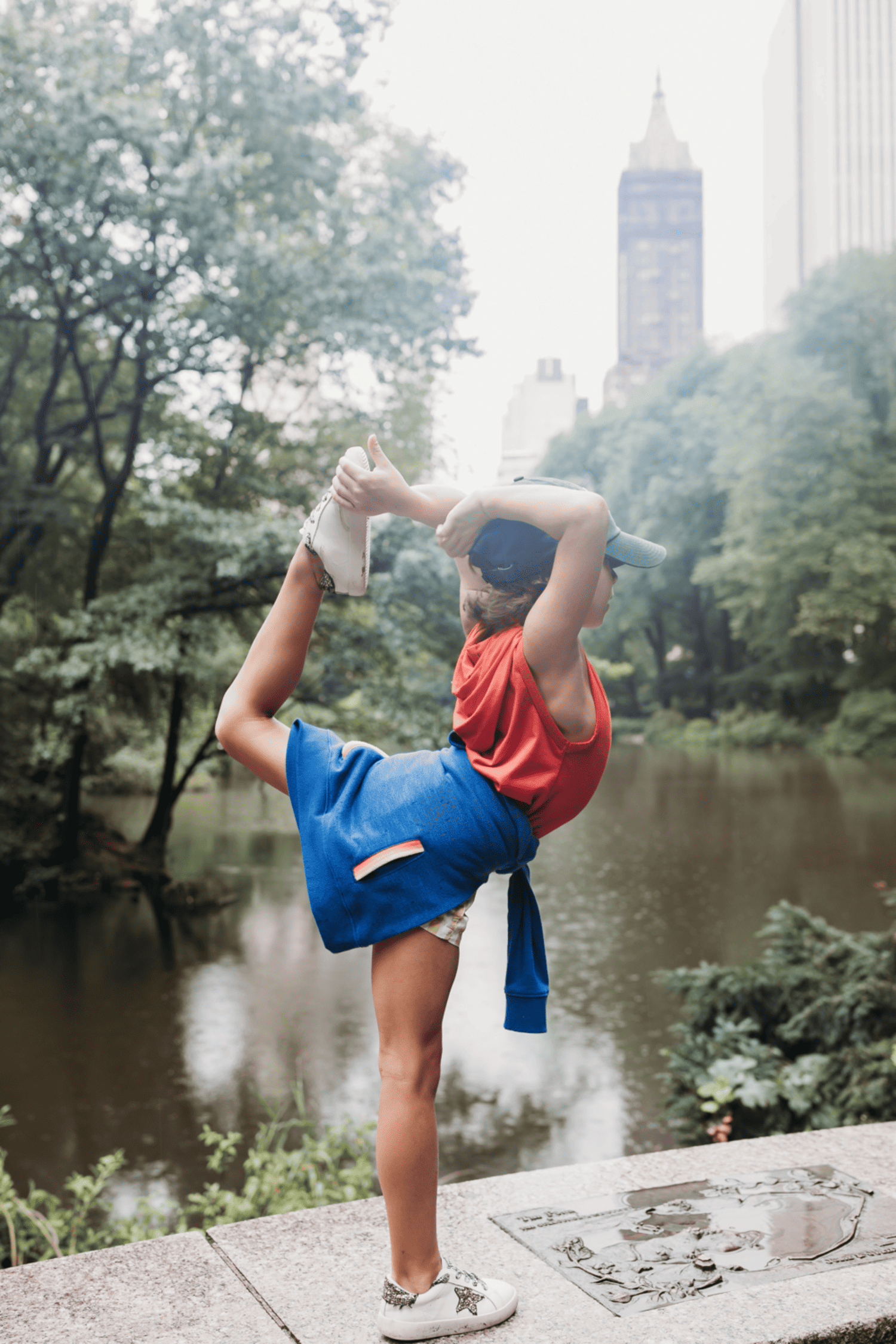 boy holding dance pose in front of water