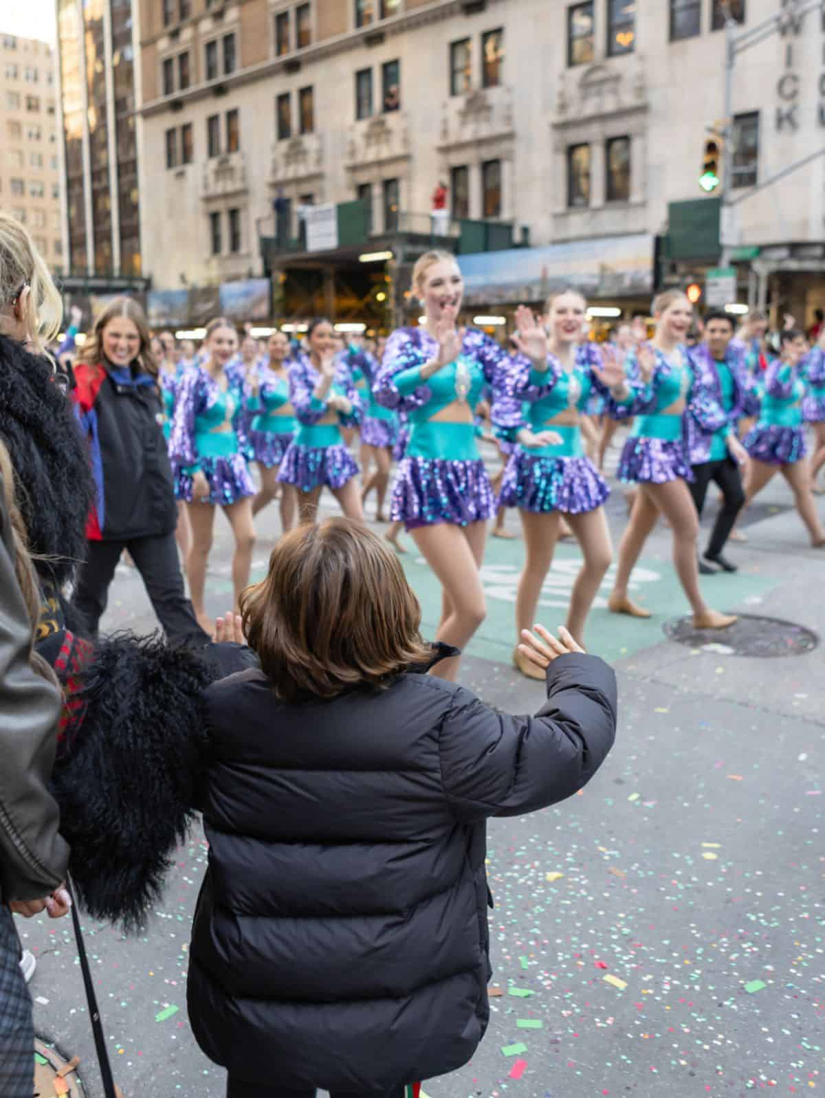 child waving to ladies walking in parade