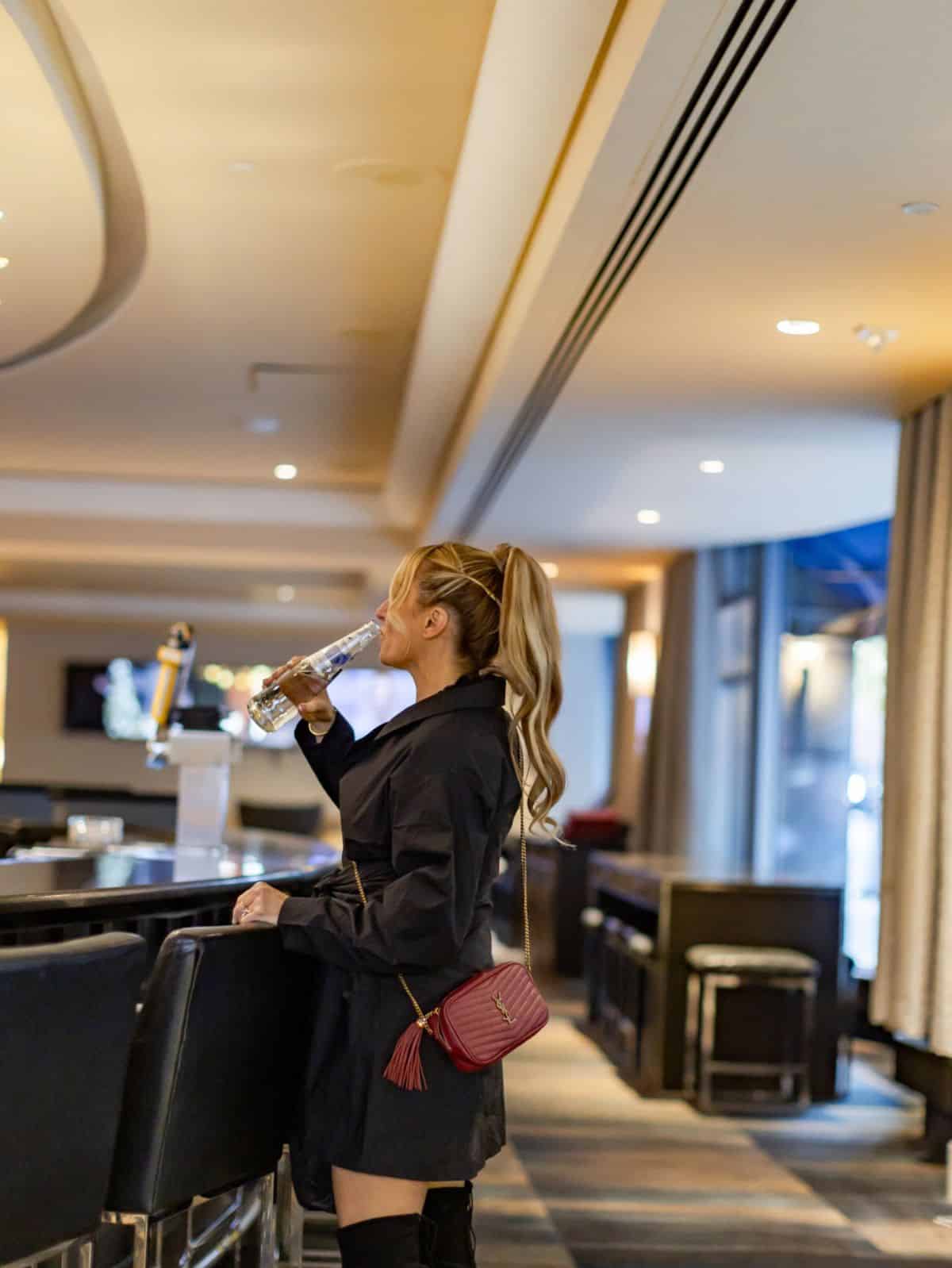 woman at bar drinking from a glass