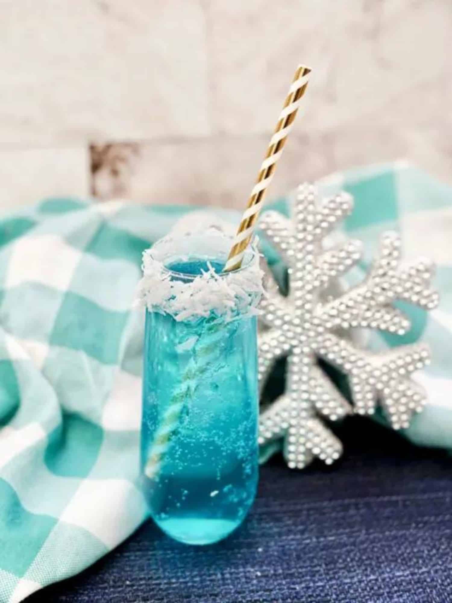 blue cocktail in a clear glass with a snowflake decoration