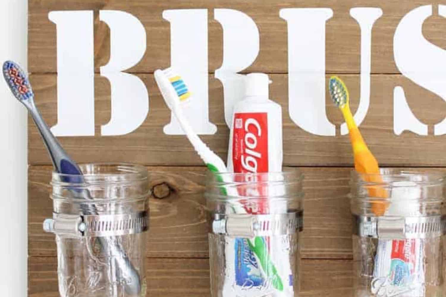 diy brush sign with mason jars holding tooth brushes